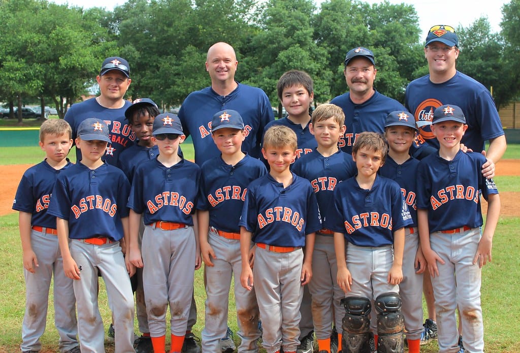 Youth baseball team smiling in their uniforms